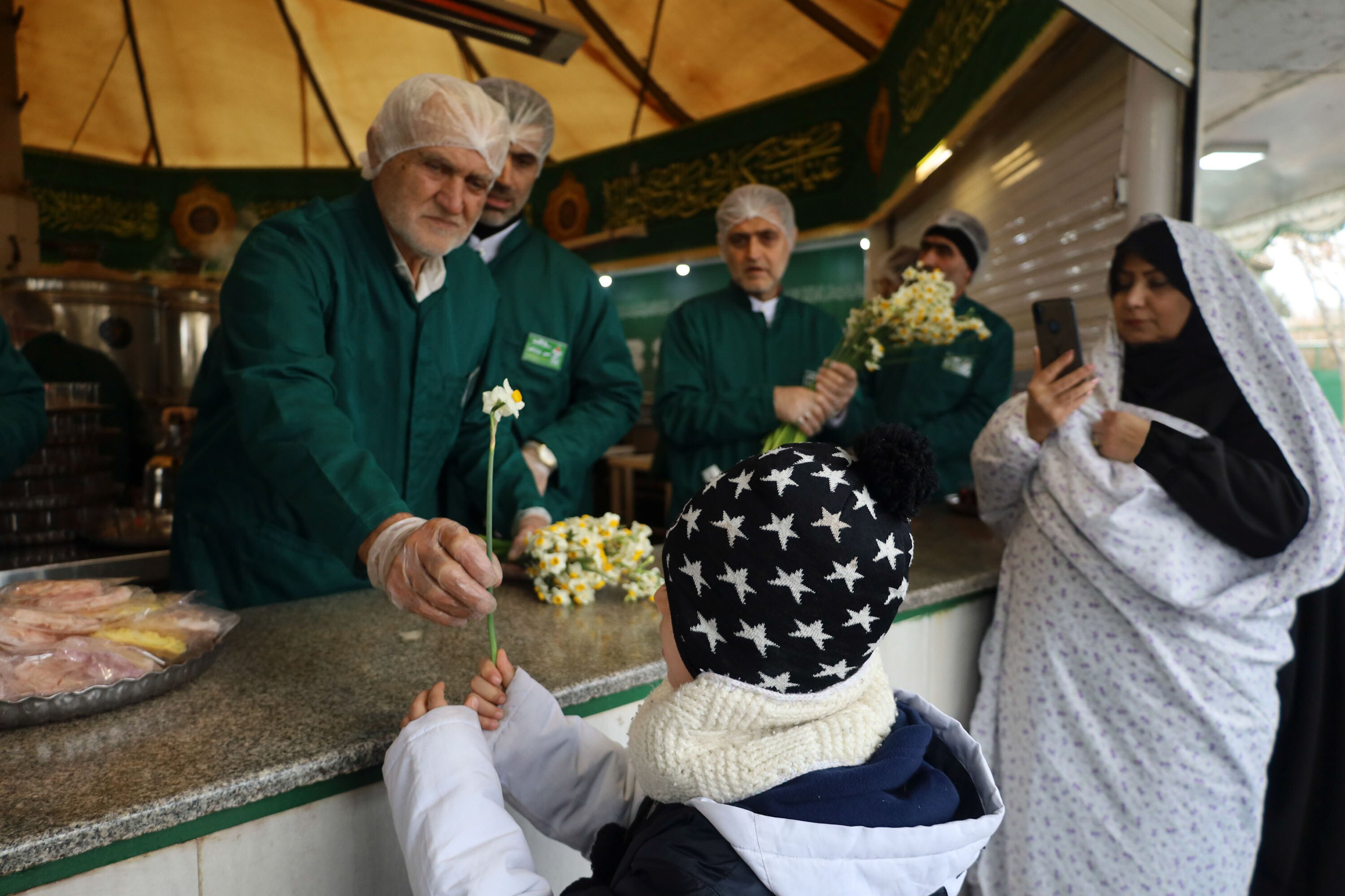 توزیع گل نرگس در چایخانه حرم مطهر رضوی