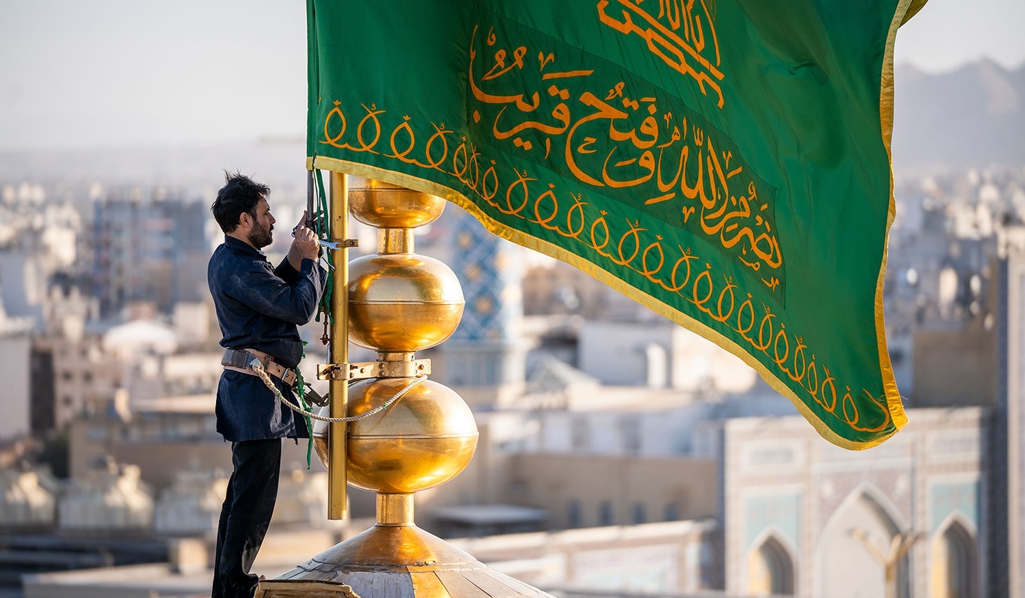 اهتزاز  پرچم کاروان اعزامی به جبهه مقاومت بر فراز گنبد منور رضوی+ فیلم